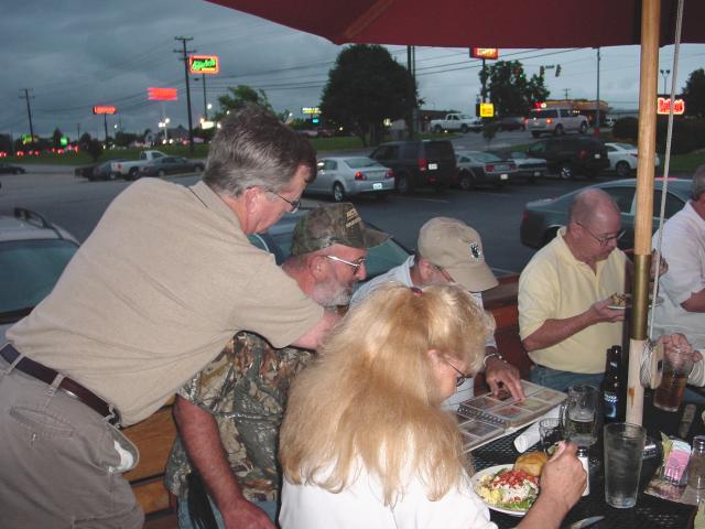 Tom Weides, Glenn Green, & Jim Roesch go through a photo album
